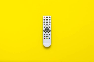 Gri uzaktan kumanda üzerindeki sarı bir arka plan. Televizyon, film, Tv şovları, spor, gece ve gündüz kavramı. Düz yatıyordu, en iyi görünümü