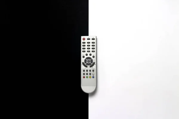 Gray remote control on a black and white background. The concept of television, movies, TV shows, sports, day and night, 24 7, for adults, for children. Flat lay, top view