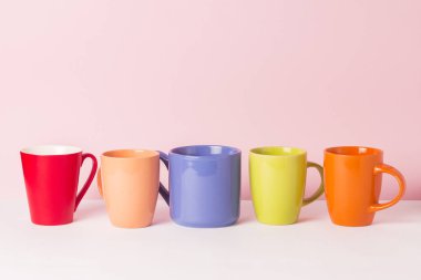 Bir sürü kahve veya çay pembe bir arka plan üzerinde renkli bardak. Bir dostu firma, büyük bir aile, bir fincan çay ya da kahve için toplantı arkadaşlar kavramı