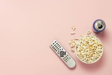 Bir kase patlamış mısır, bir Tv Uzaktan kumanda, pembe bir arka plan üzerinde içki bir kavanoz. Tarassut Tv, film, Tv dizisi, spor, kavramı gösterir. Düz yatıyordu, en iyi görünümü