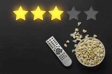 Patlamış mısır ve Tv bir siyah arka plan üzerinde uzaktan ile top. A beğenilme-in üç yıldız eklendi. Kavramı terk geribildirim, ün film, gösteri, serisi, kanal. Düz yatıyordu, en iyi görünümü