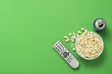 Bir kase patlamış mısır, bir Tv Uzaktan, bir kutu yeşil bir arka plan üzerinde bir içkiyle. Tarassut Tv, film, Tv dizisi, spor, kavramı boş olarak gösterir. Düz yatıyordu, en iyi görünümü