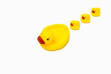 Kauçuk oyuncak sarı renk anne ördek ve beyaz bir arka plan üzerinde küçük ördek yavrusu. Anne bakım ve çocuklar için aşk kavramı.