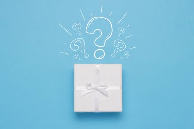 Beyaz hediye kutusu ve simge soru işareti mavi bir arka plan üzerinde. Minimalist tarzı. Kavram sürpriz ve gerilim. Düz yatıyordu, en iyi görünümü.