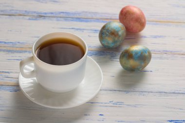 Paskalya yumurtaları ve kahve ahşap masa üzerinde. Paskalya kavramı.