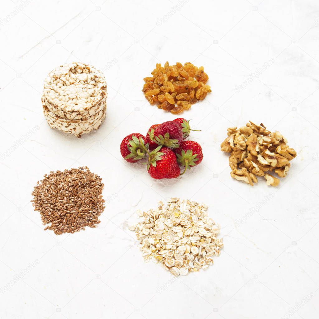 Natural sources of minerals. Oat flakes, flaxseeds, strawberries, rice loaves, walnuts and raisins. Concept of healthy eating