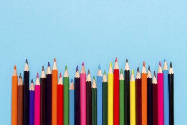 Renkli kalemler mavi bir arka plan bir dalga şeklinde ortaya koydu. Düz yatıyordu, en iyi görünümü.