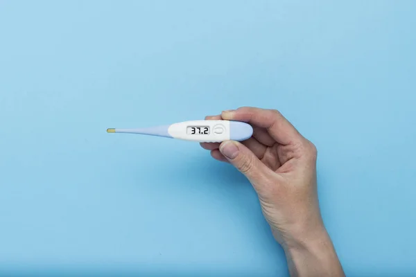 Female Hand Holds Electronic Thermometer Showing Temperature Degrees Blue Background — Stock Photo, Image