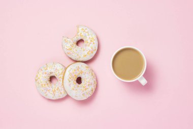 Beyaz fincan, kahve ya da çay süt ve taze lezzetli tatlı çörek üzerinde pembe bir arka plan ile. Fırın kavramı, taze hamur işleri, lezzetli breakfast, lokanta. Düz yatıyordu, en iyi görünümü