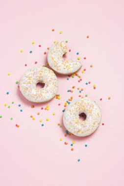 Taze lezzetli tatlı çörek, çok renkli dekoratif şekerleme, pembe bir arka plan üzerinde kesme şeker. Fırın kavramı, taze hamur işleri, lezzetli breakfast, lokanta. Düz yatıyordu, en iyi görünümü