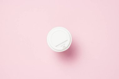 Kağıt bardak bir plastik kapak, kahve veya çay, pembe bir arka plan ile. Fast food kavramı, ekmek, Kahvaltı, şekerleme, kahve dükkanı, take-away gıda. kopya alanı. Düz yatıyordu, en iyi görünümü
