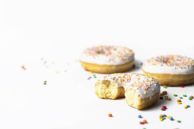 Taze lezzetli donuts ve tatlı çok renkli dekoratif şeker beyaz zemin üzerinde. Fırın kavramı, taze hamur işleri, lezzetli kahvaltı