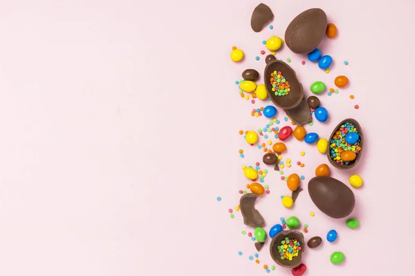 破碎和整个巧克力复活节彩蛋 五颜六色的糖果 粉红色的背景 庆祝复活节 复活节装饰的概念 平坦的平面 顶部的景色 复制空间 复活节快乐 — 图库照片