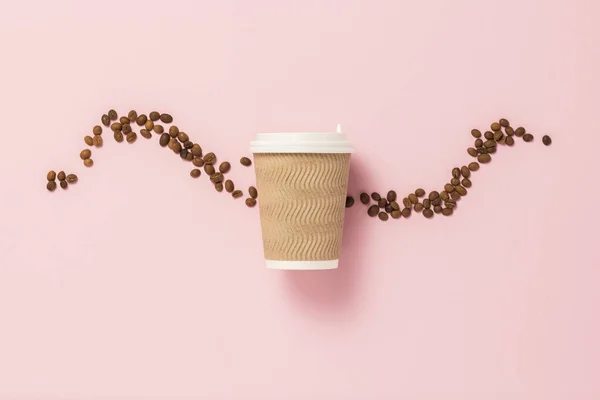 Disposable paper cup with a plastic lid for hot coffee or tea on a pink background with grains of coffee. Flat lay, top view