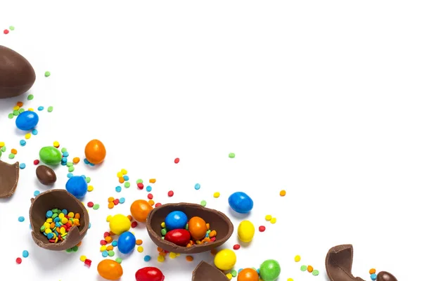 破碎和整个巧克力复活节彩蛋 五颜六色的糖果在白色背景 庆祝复活节 复活节装饰的概念 寻找复活节兔子糖果 平坦的平面 顶部的景色 复制空间 — 图库照片