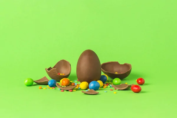Velikonoční Čokoládové Vajíčko Pestrobarevným Sladkosti Rozbité Čokoládová Vajíčka Zeleném Pozadí — Stock fotografie