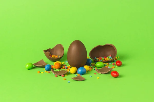 Velikonoční Čokoládové Vajíčko Pestrobarevným Sladkosti Rozbité Čokoládová Vajíčka Zeleném Pozadí — Stock fotografie