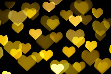 Siyah arka planda güzel sarı ve beyaz bir bokeh. Arkaplan ya da duvar kağıdı olarak kullanılabilir. Kalp şeklinde. Aşk Konsepti, Sevgililer Günü
