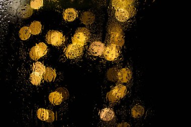 Bokeh gece şehir ışıkları sırasında yağmur ıslak cam arkasında. Duvar kağıdı veya arka plan kullanılabilir