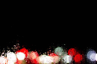 Bokeh gece şehir ışıkları sırasında yağmur ıslak cam arkasında. Duvar kağıdı veya arka plan kullanılabilir