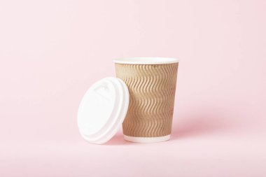 Kağıt bardak pembe bir arka plan üzerinde plastik bir kapak ile. Sıcak bir içecek kavramı, çay veya kahve, paket servisi olan Restoran