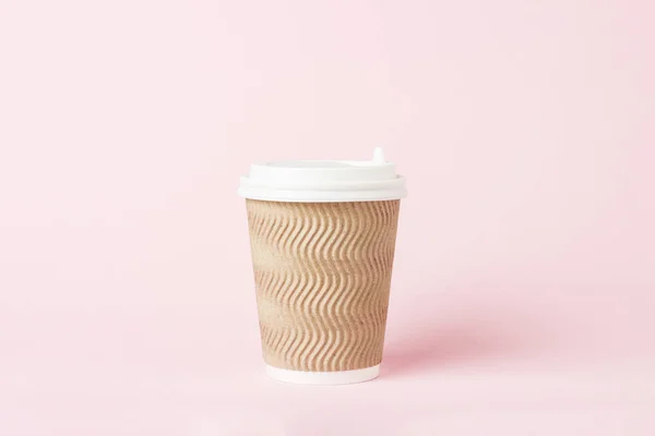 Paper cup with a plastic lid on a pink background. Hot drink concept, tea or coffee, takeaway