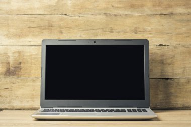 Ahşap arka plan üstünde laptop. Ev ofis kavramı, serbest, evde çalışma