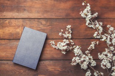 Sakura dalları çiçek ve koyu ahşap arka plan üzerine bir kitap ile