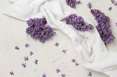 Havlu ve eflatun çiçekler beyaz bir arka plan üzerinde beyaz. Üstten görünüm, düz, yatıyordu, kopya alanı.