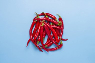 Mavi bir arka plan karşı bir daire şeklinde dizilmiş kırmızı sıcak Şili biber. Düz yatıyordu, en iyi görünümü