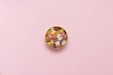 Bir turda çok renkli lolipop yavaşça pembe bir arka plan üzerinde olabilir. Tatlı ve şekerleme kavramı. Tatlı hediye. Tatlı aşk. Meyve lezzet. Düz yatıyordu, en iyi görünümü