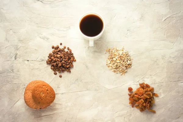 Cookie-kat, zabpehely, kávé, mazsola és egy csésze kávét a világos háttér. A javaslatok egy ék formájában lefektetett. Reggeli koncepció. Megszámlálását — Stock Fotó