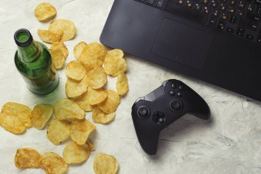 Dizüstü bilgisayar, Gamepad, patates cipsi, şişe bira hafif bir taş b