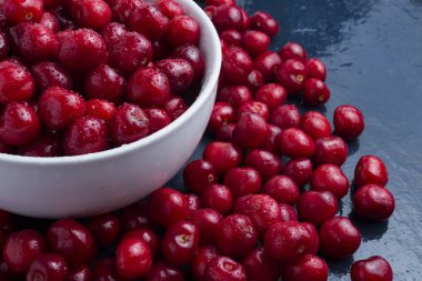 Damla çiğ ve su beyaz bir yay ile taze çekilmiş kiraz