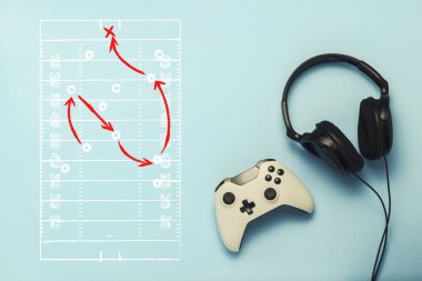 Kulaklık ve gamepad üzerinde mavi bir arka plan. Oyun taktikleri ile çizim eklendi. Amerikan futbolu. Bilgisayar oyunları, eğlence, oyun, eğlence kavramı. Düz yatıyordu, en iyi görünümü