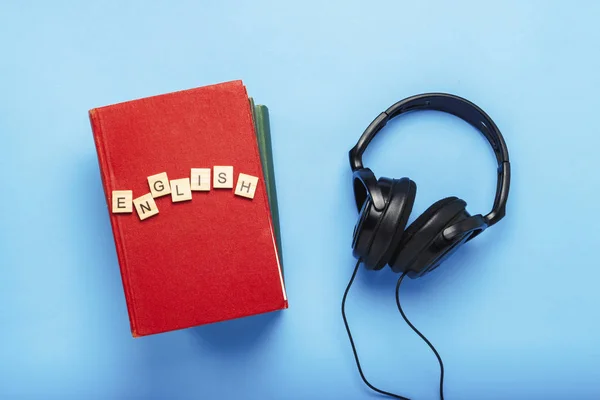 Boek met rode kaft met tekst Engels en zwarte hoofdtelefoon op — Stockfoto