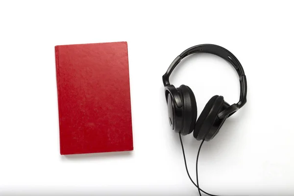 Boeken met een rode en zwarte hoofdtelefoon op een witte achtergrond — Stockfoto