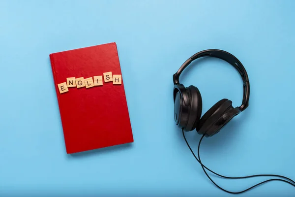 Boek met rode kaft met tekst Engels en zwarte hoofdtelefoon op — Stockfoto