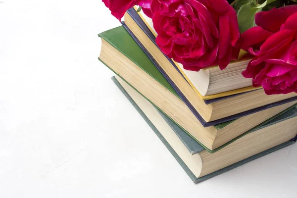 Um buquê de rosas vermelhas em uma pilha de livros em um backg de pedra leve — Fotografia de Stock