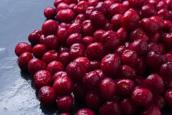 Cerejas recém-colhidas com gotas de orvalho e água em um bl escuro — Fotografia de Stock