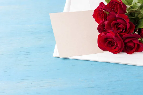 Ramo de rosas rojas, sábana limpia, fondo de madera azul. Copiar sp — Foto de Stock