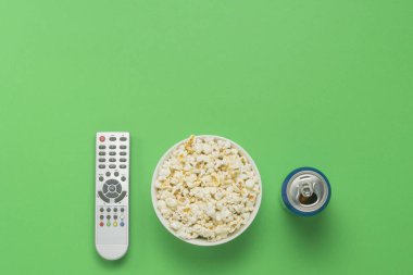 Bir kase patlamış mısır, bir Tv Uzaktan, bir kutu yeşil bir arka plan üzerinde bir içkiyle. Tarassut Tv, film, Tv dizisi, spor, kavramı boş olarak gösterir. Düz yatıyordu, en iyi görünümü.