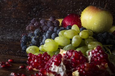 Üzüm çeşitleri, nar, nar taneleri, elma suyu bir ahşap zemin üzerine su sıçramalarına. Taze meyve kavramı, yeni ürün