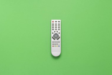 Gri uzaktan kumandadaki yeşil bir arka plan. Televizyon, Film, Tv şovları, spor, gece ve gündüz kavramı. Düz yatıyordu, en iyi görünümü.