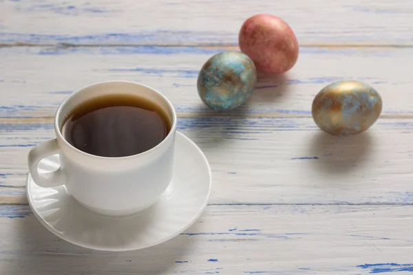 Easter Eggs and Cup of Coffee on the Wooden Table. Easter concept