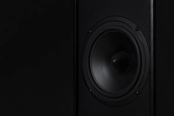 Black Music speaker on a black isolated background. Party or music listening concept.