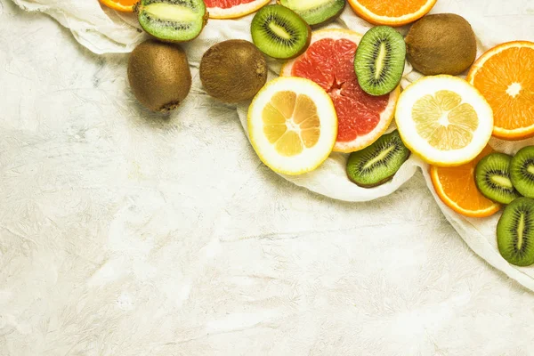 Frutas frescas, pomelo, limón, naranja, kiwi sobre un fondo de piedra clara. Copiar espacio y una vista superior — Foto de Stock