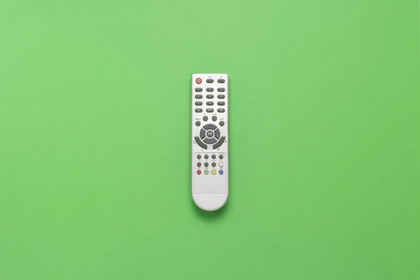 Controle remoto cinza em um fundo verde. O conceito de televisão, filmes, programas de TV, esportes, dia e noite. Deitado plano, vista superior . — Fotografia de Stock