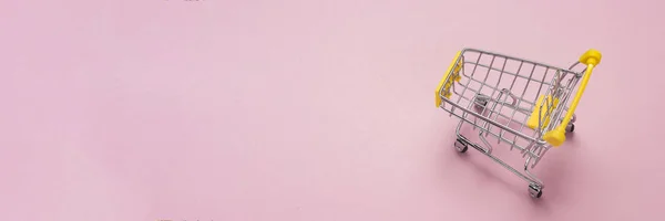 Einkaufswagen aus dem Supermarkt auf isoliertem rosa Hintergrund. Einkaufen im Einkaufszentrum, einkaufen, einkaufen. flache Lage, Draufsicht. Kopierraum. Banner — Stockfoto