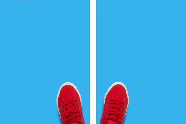 Pernas em tênis vermelhos em um fundo azul e separando a faixa branca. Conceito de escolha. Deitado plano, vista superior — Fotografia de Stock